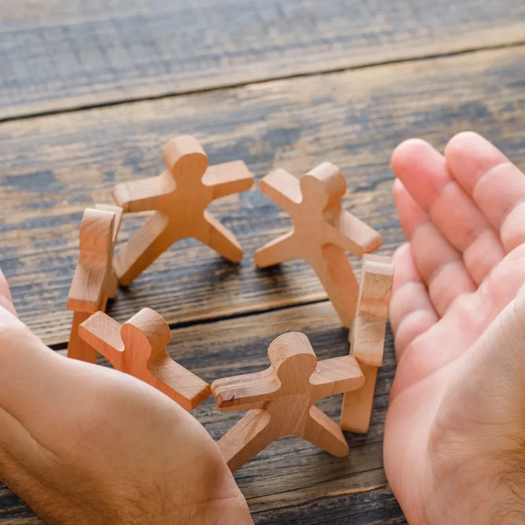 business-success-concept-wooden-table-top-view-hands-protecting-wooden-figures-people